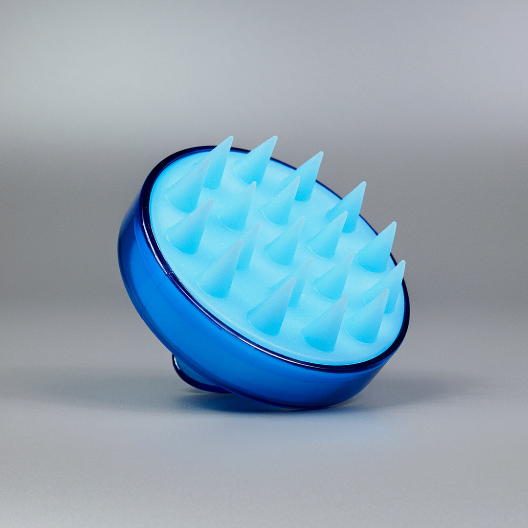 Die Dr. Balwi Massagebürste von shop.elithairtransplant, ein blauer Kopfhautmassager aus Silikon mit spitzen Borsten, ist ideal für Kopfmassage und Kopfhautpflege und wird vor einem schlichten grauen Hintergrund abgebildet.